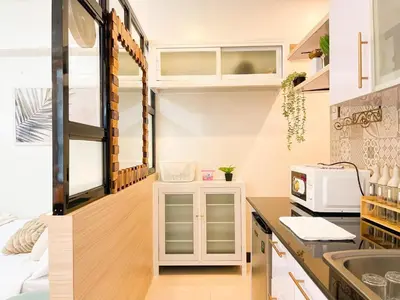 a kitchen with white cabinets and a microwave at Prime Condo Living Near Venice Canal #msert26k in Manila