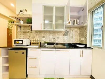 a kitchen with white cabinets and a sink at Prime Condo Living Near Venice Canal #msert26k in Manila