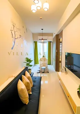 a living room with a black couch and yellow pillows at 1 Bed Room Coast Residence at Heart of Metro Manila - Pasay City in Manila