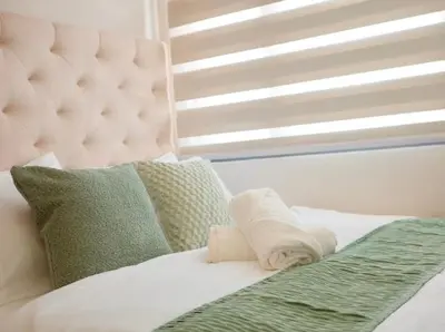 a white bed with a pillow and a window at Golden Scape 1 Bedroom near NAIA Airport in Manila