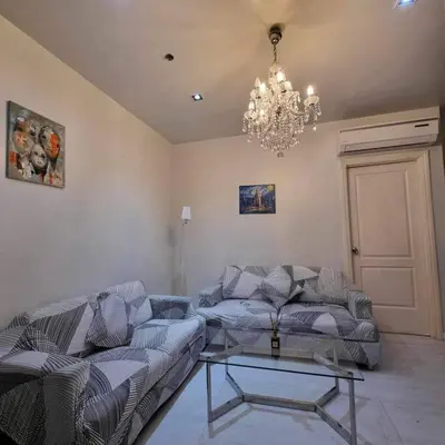 a living room with two couches and a chandelier at Gramercy Residences Two Bedroom on 60th Floor in Manila