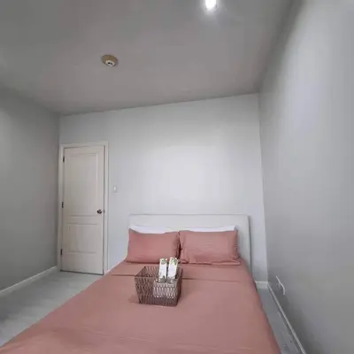a bedroom with a pink bed with a basket on it at Gramercy Residences Two Bedroom on 60th Floor in Manila