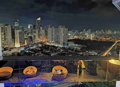 a view of a city skyline at night at 66F 1 BR Penthouse with 2 Balconies Panoramic View in Manila