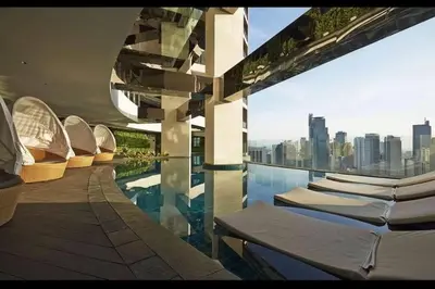 a swimming pool with lounge chairs on a building at 66F 1 BR Penthouse with 2 Balconies Panoramic View in Manila