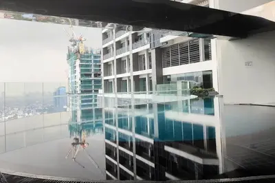 a reflection of a building in a pool of water at 52F Sunset View Studio in Gramercy Pool Gym Sauna in Manila
