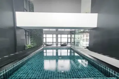 a large swimming pool in a building with a large ceiling at 52F Sunset View Studio in Gramercy Pool Gym Sauna in Manila
