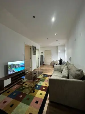 a living room with a couch and a flat screen tv at Spacious Corner 1 Bedroom with Balcony Gramercy in Manila