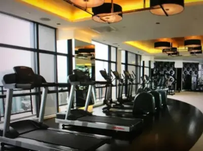 a gym with a row of treadmills and elliptical machines at 58F Minimalist Studio Panoramic View in Gramercy in Manila