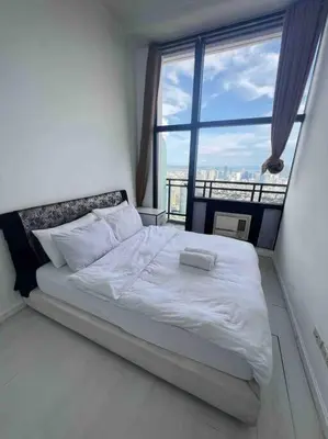a white bed in a room with a large window at 64F Spacious 1 BR Nice View Pool Sauna Gym in Manila