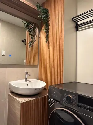 a bathroom with a sink and a washing machine at El Suite in Puting Kahoy