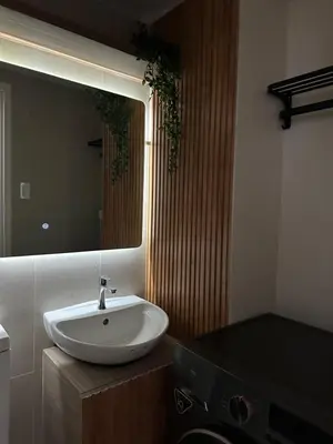 a bathroom with a white sink and a mirror at El Suite in Puting Kahoy