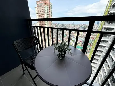 a white table and chairs on a balcony with a view at Cozy Space in Makati - Margareth Suite in Manila