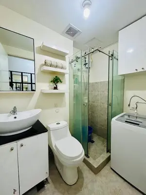 a bathroom with a toilet and a sink and a shower at Cozy Studio Unit Near MRT Shaw & Malls in Manila