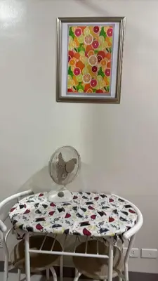 a table and chair with a painting on the wall at Solana Tower 1 New and Very Neat Studio Unit near SM Manila in Manila