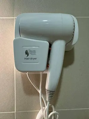 a hair dryer is hanging on a wall at Cozy 1BR nr Ortigas Makati & BGC with Secured Parking in Manila
