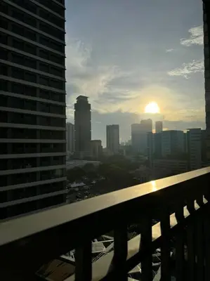 a view of a city skyline with the sun setting at Cozy 1BR nr Ortigas Makati & BGC with Secured Parking in Manila