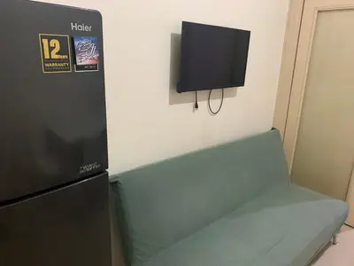 a room with a refrigerator and a tv on a wall at CASSa LISHA in Manila