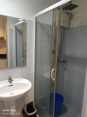 a bathroom with a sink and a glass shower at Flores Place At Sea Residences MOA in Manila