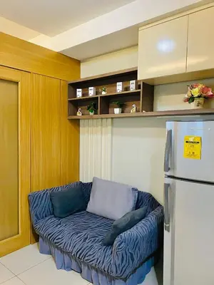 a blue couch in a kitchen with a refrigerator at Condotel By RhoiVC in Shell Residences Moa Near Naia Airport in Manila