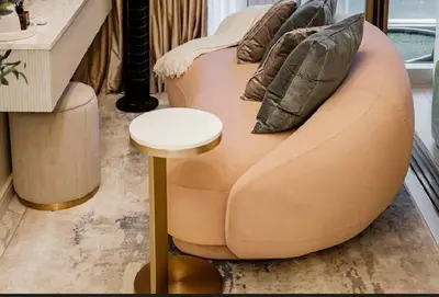 a brown couch with a stool in a room at Lamour Talia in Manila