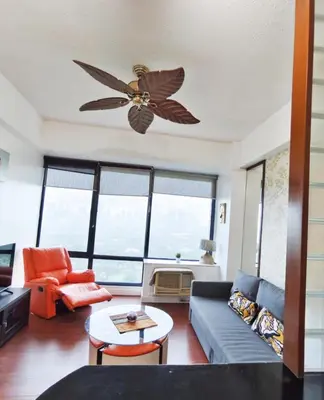 a living room with a couch and a ceiling fan at Bellagio One Bedrroom BGC Burgos Circle by Christine Suites PH in Manila