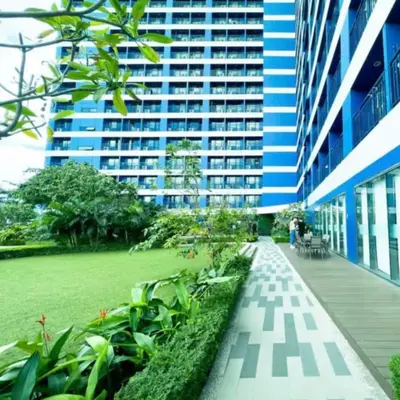 a building with a walkway in front of a park at Air Residence in Manila