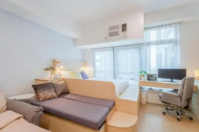 a bedroom with a bed and a desk with a computer at Eastwood LeGrand 3 with Ogawa MasterdrivePlus, No Pets Allowed in Manila