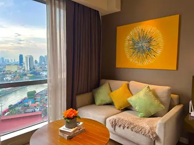 a living room with a couch and a large window at The Residences at Novotel Tower in Manila