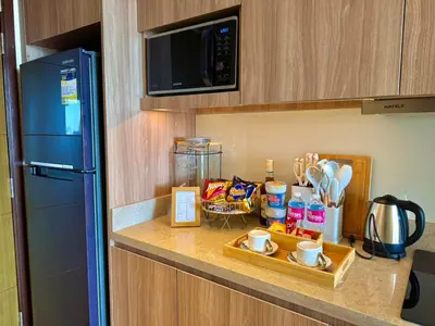 a kitchen with a counter top with a microwave and a refrigerator at The Residences at Novotel Tower in Manila