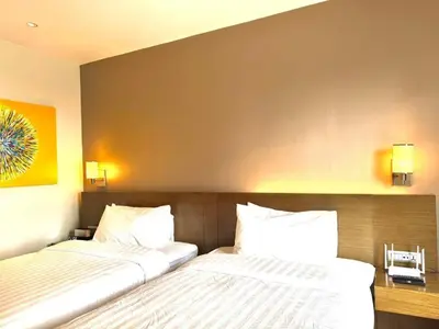 two beds sitting next to each other in a bedroom at The Residences at Novotel Tower in Manila
