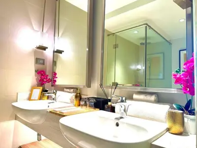 a bathroom with two sinks and a large mirror at The Residences at Novotel Tower in Manila