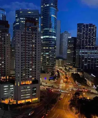 a city skyline with tall buildings and traffic at night at Air Residences - Pool View near Airport - 1159 in Manila
