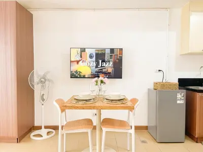 a kitchen with a table with chairs and a refrigerator at Chic BGC Condo by Grand Canal Mall #vlrtb27b in Manila