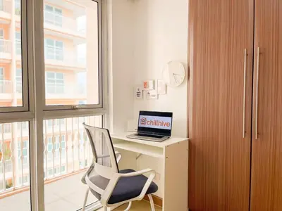a room with a desk with a laptop and a chair at Chic BGC Condo by Grand Canal Mall #vlrtb27b in Manila