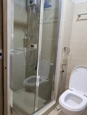 a bathroom with a toilet and a glass shower at One Bedroom Condo Unit Fame Residences Tower 4 in Manila