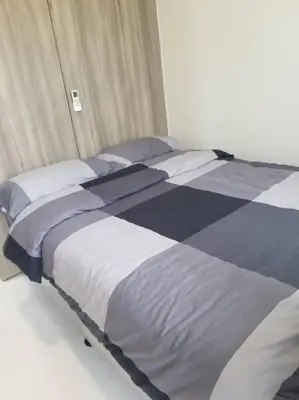 a bed with blue and white sheets and pillows at One Bedroom Condo Unit Fame Residences Tower 4 in Manila