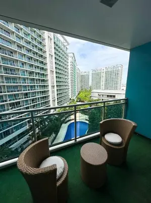 a balcony with two chairs and a view of a city at Casa Alivia at Azure UrbanResort in Manila