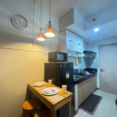 a small kitchen with a table with plates on it at The J-MA UltiEscape Charm Residences Condo in Manila
