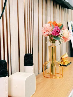 a vase of flowers on a table with a speaker at MOA Staycation Haven Cozy 1BR Retreat with Balcony at Shore 3 in Manila