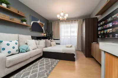 a living room with a bed and a couch at Newly Renovated Pasig Studio with Pool and Fiber Wi-Fi in Manila