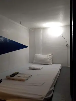 a white room with a bed with a light on it at RDC - Mariveles Transient Capsule in Manila