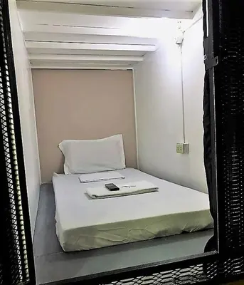 a mirror reflecting a bed in a small room at RDC - Mariveles Transient Capsule in Manila
