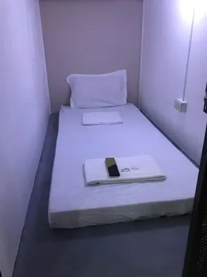 a small room with a bed with a phone on it at RDC - Mariveles Transient Capsule in Manila