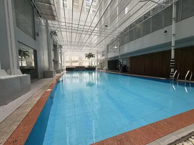 a large swimming pool in a large building at Studio deluxe cozy staycation Antel Spa Residences in Manila