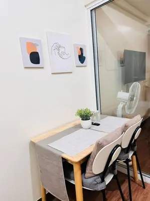 a dining room table with two chairs and a table at 1-BR Condo with Pool & Skyline Views in Pasig in Manila