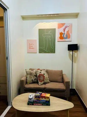 a living room with a couch and a coffee table at 1-BR Condo with Pool & Skyline Views in Pasig in Manila