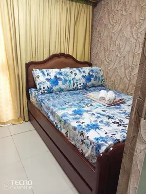 a bed with a blue and white comforter with a plate on it at Sea res moa by Elsie D in Manila