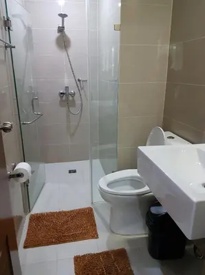 a bathroom with a shower and a toilet and a sink at Newport City Condos in Manila