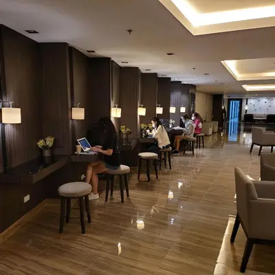 a lobby of a hotel with people sitting at tables at Air Residences - Pool View Balcony near Airport - 4576 in Manila