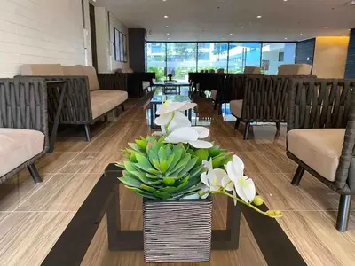 a lobby with a vase of flowers on a table at Air Residences - Balcony Pool View near Airport - 1721 in Manila